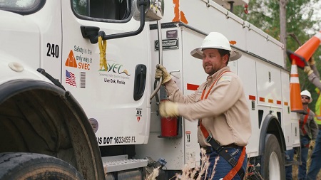 Suwannee Valley Electric Cooperative worker getting in bucket truck