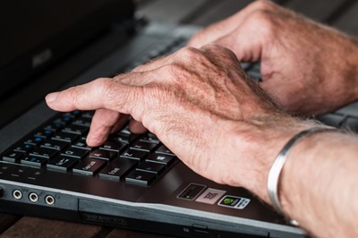 older adult hands on computer