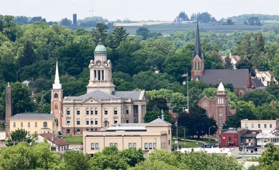 Aerial view of Decorah with steeples jutting into the skyline amid lush greenery