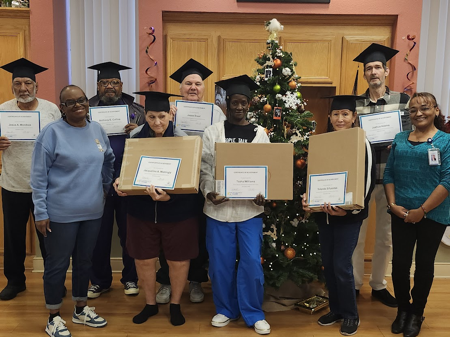 Belinda Parker-Mendoza (far right) stands with a half dozen graduates of the Americorps VISTA digital skills class