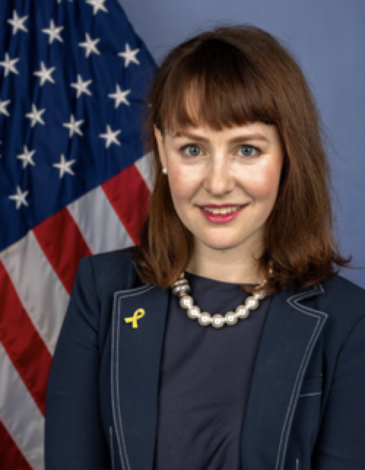 Arielle Roth headshot in front of American flag